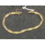 Yellow metal three bar gate bracelet, tests as 14ct gold. Weight 11.8g.