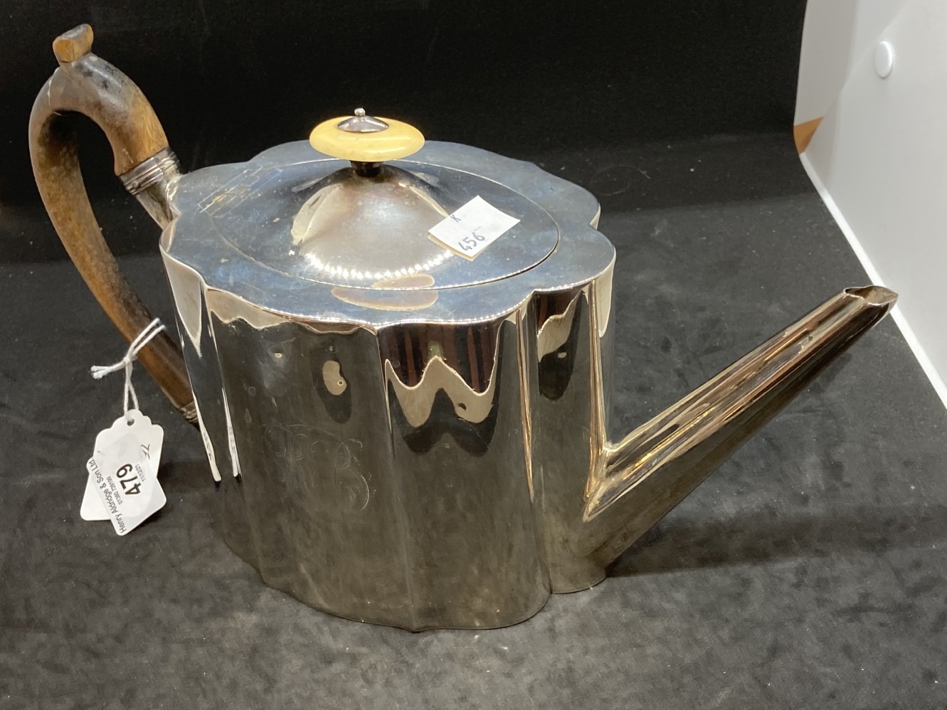 Hallmarked Silver: Georgian teapot, serpentine decorated body, hinged cover, wooden handle.