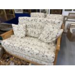 Ercol Bergere solid ash and cane settee and pair of armchairs with leaf pattern upholstery.