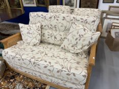 Ercol Bergere solid ash and cane settee and pair of armchairs with leaf pattern upholstery.