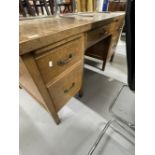 20th cent. Oak five drawer desk with two brushing slides on square legs terminating with brass caps,