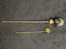 Yellow metal stick pins, one set with a rose cut diamond, the other with a carved agate in the