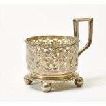 SILVER CUP HOLDER WITH CHISELED FLORAL DECORATION ON THREE SPHERICAL LEGS. Firm [...]