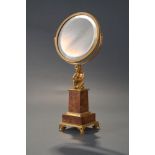 GILDED BRONZE FRAMED MIRRORset on marble column with square base. The mirror is held by a kneeling