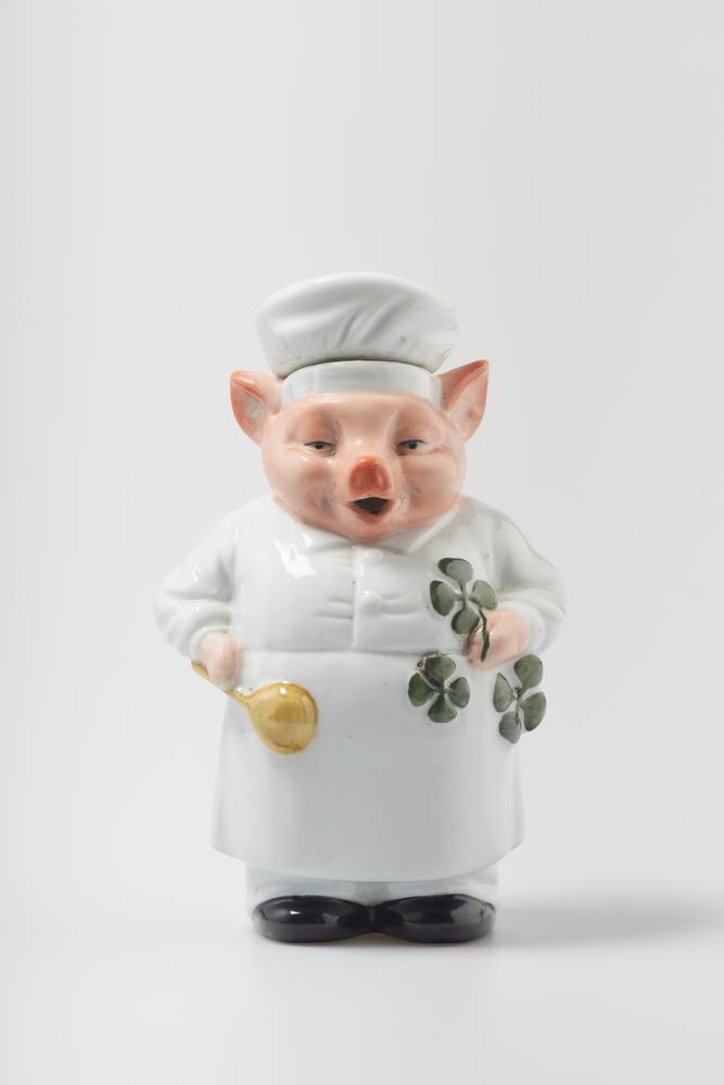 CERAMIC PIG FIGURINE Ceramic with glaze In the shape of a pig dressed as a cook, holding a cooking