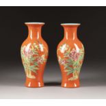 A PAIR OF RED-GROUND FAMILLE ROSE BALUSTER VASES