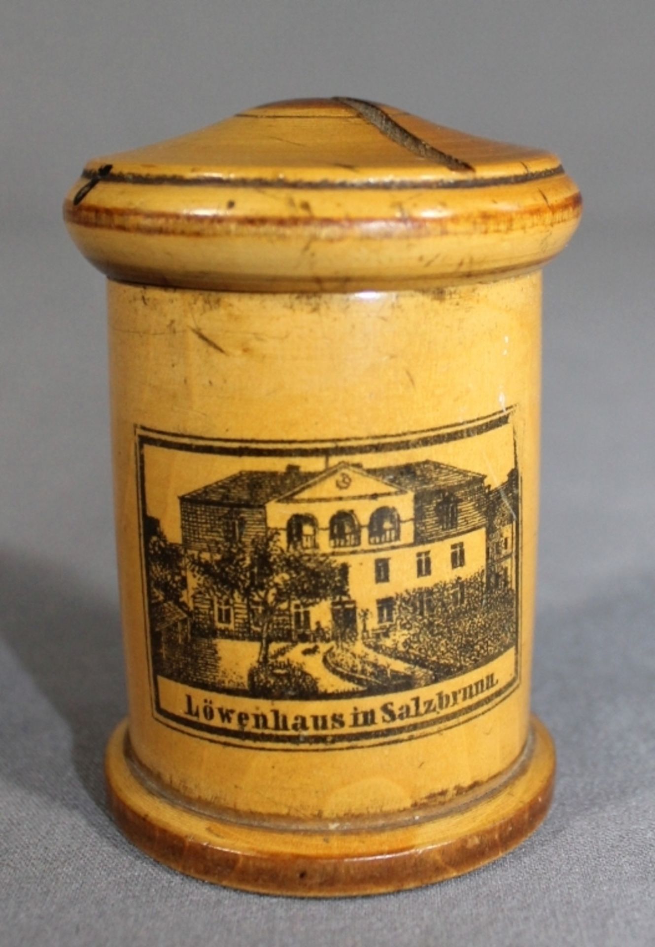 1 kleine zylinderförmige Spardose Holz, schauseitig mit Ansicht vom Löwenhaus in Salzbrunn,