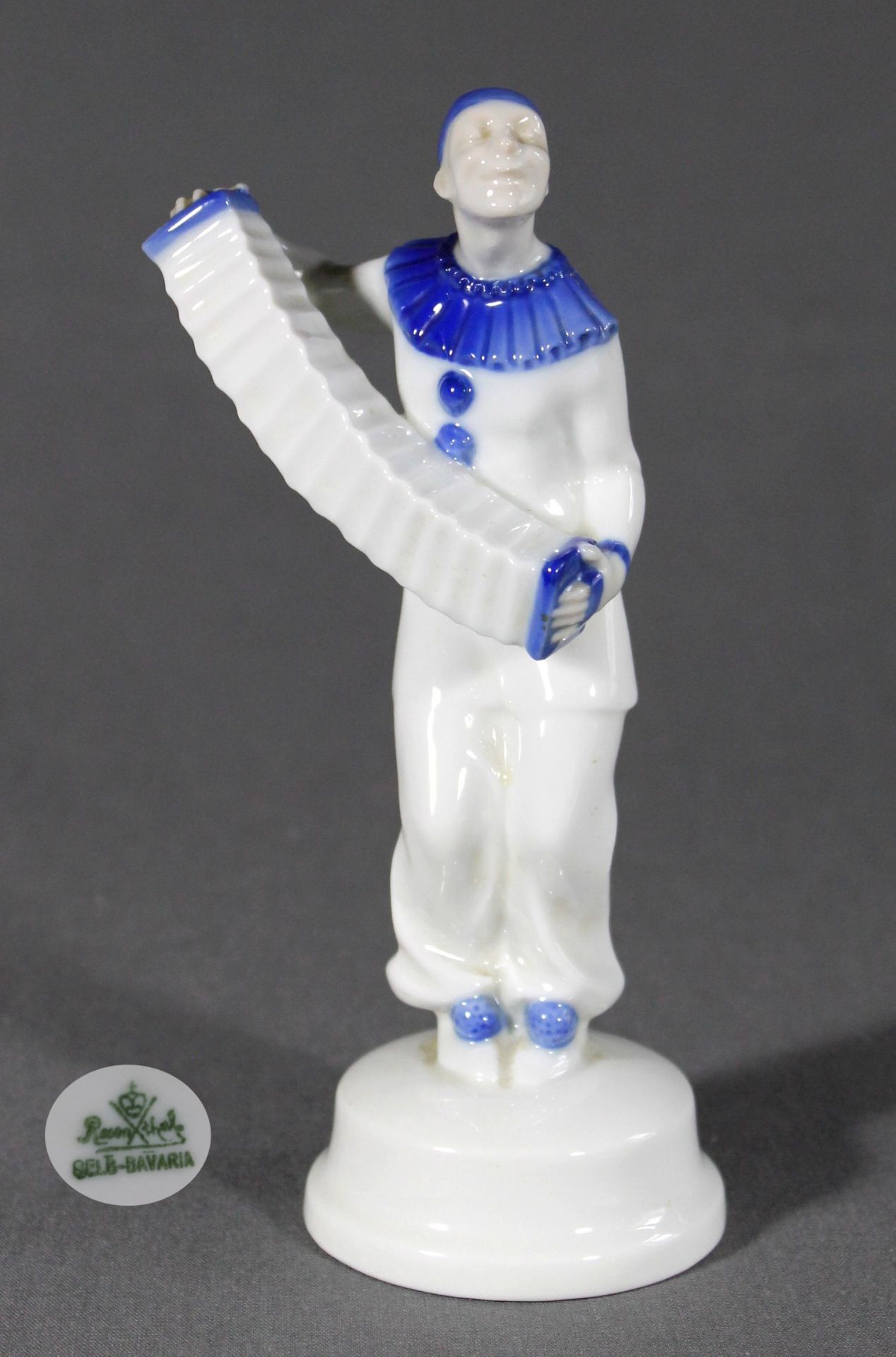 1 Porzellanfigur Jugendstil, auf rundem Sockel „Zieharmonika spielender Pirrot, Hutschenreuther“,