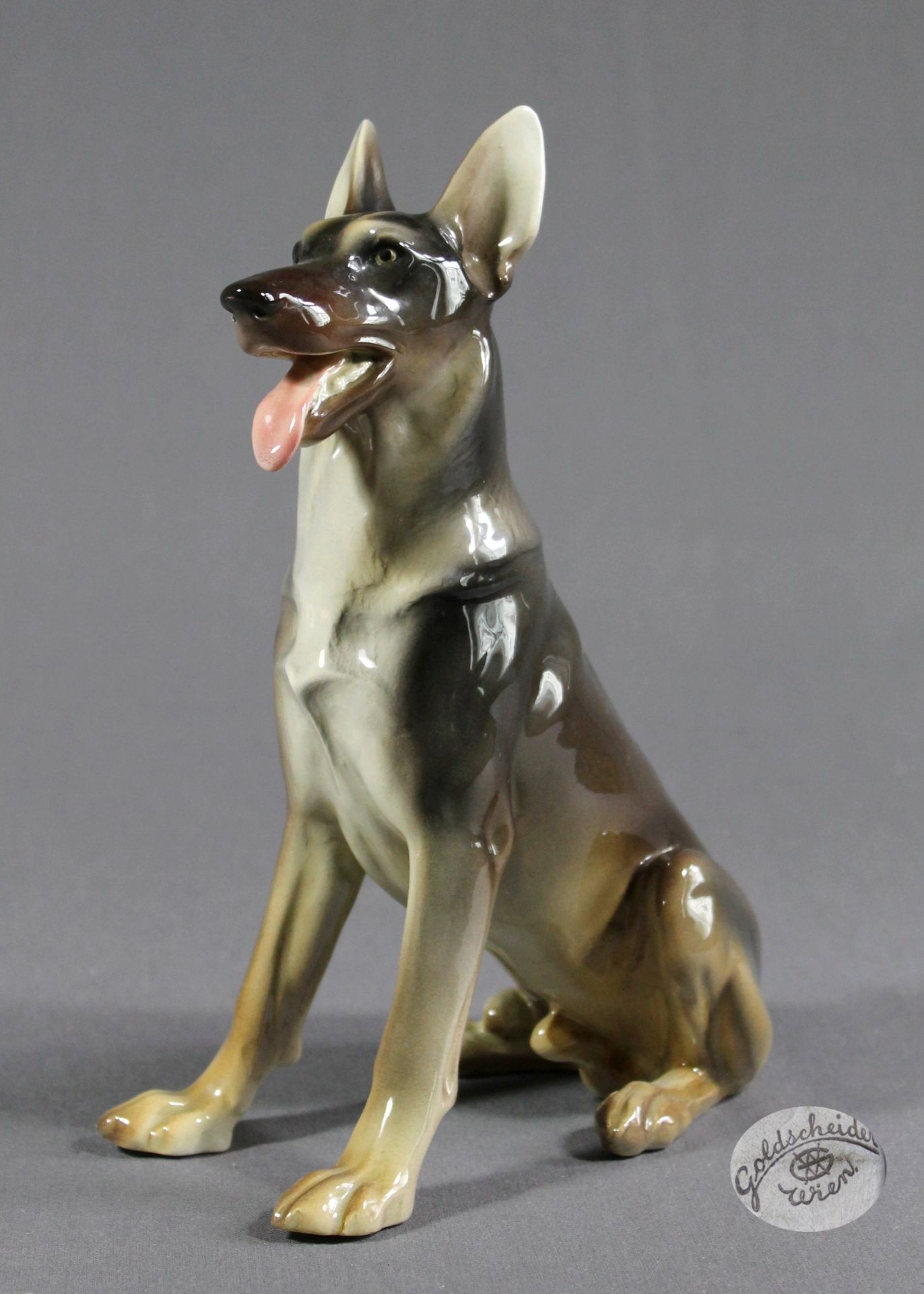 1 Keramikfigur „sitzender Schäferhund, Goldscheider Wien“, nummeriert, farbig staffiert, ca. 23cm