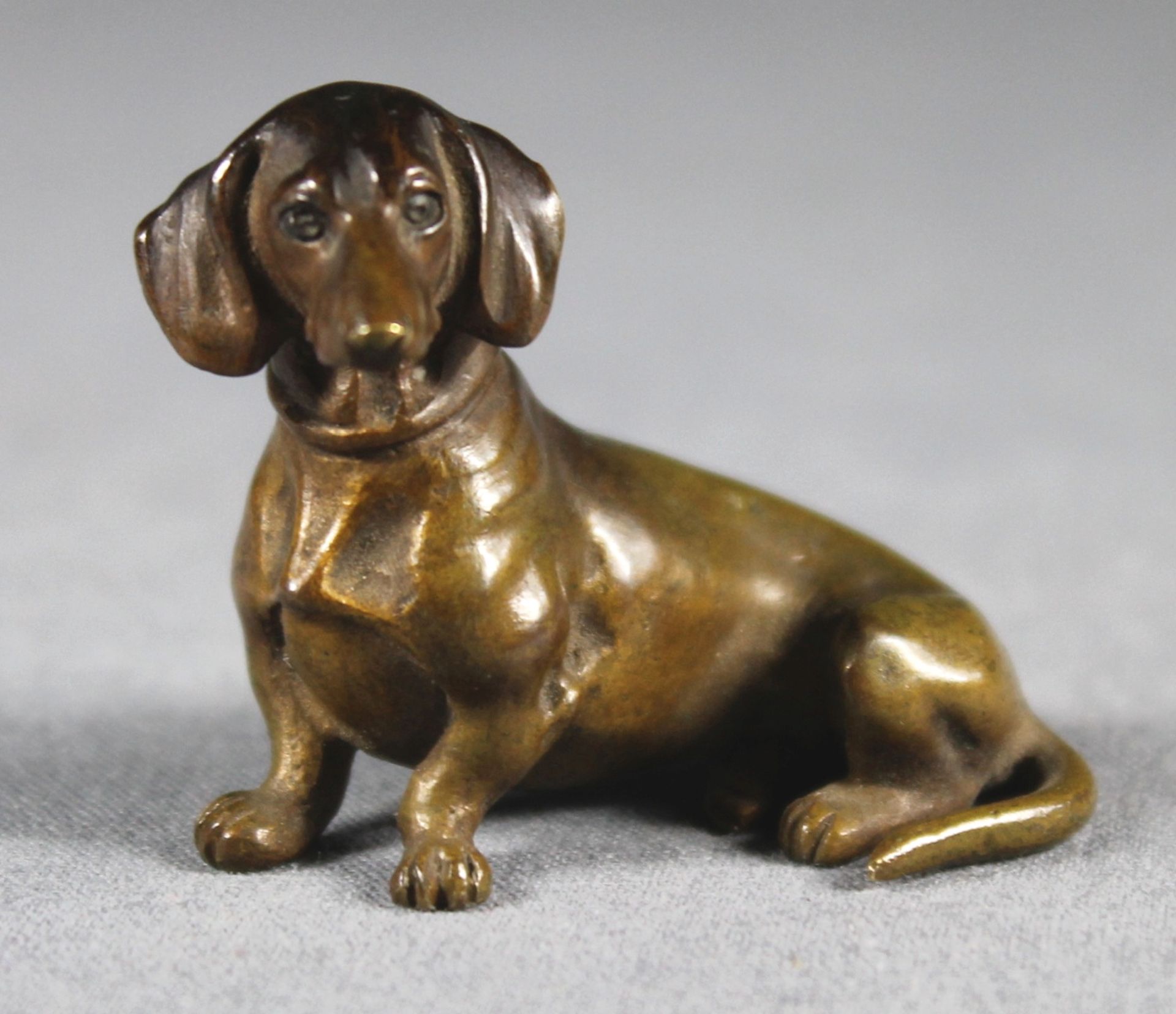 1 kleine Bronzefigur "sitzender Dackel", ca. 3,5cm x 5cm