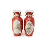 A PAIR OF RED GROUND SMALL TWIN HANDLED VASES