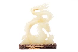 A LARGE WHITE STONE CARVING OF A DRAGON CHASING A PEARL