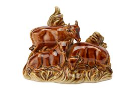 A GLAZED CERAMIC GROUP OF COWS