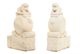 A PAIR OF LARGE CARVED STONE FOO DOGS ON DRUMS