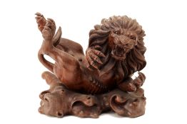A CARVED WOOD MODEL OF A LION