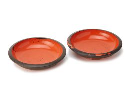 A PAIR OF ORANGE AND BLACK LACQUER SHALLOW BOWLS