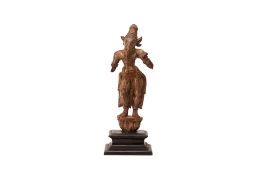 A CARVED STANDING FIGURE OF AN INDIAN DEITY