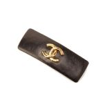 A CHANEL BLACK LEATHER AND GILT METAL BARRETTE HAIR CLIP
