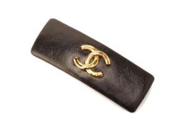 A CHANEL BLACK LEATHER AND GILT METAL BARRETTE HAIR CLIP