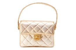 A CHANEL SMALL GOLD QUILTED FLAP BAG WITH TOP HANDLE