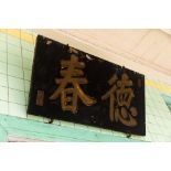 A BLACK AND GILT CHINESE SIGN