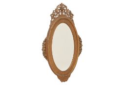 AN OVAL CARVED WOOD MIRROR