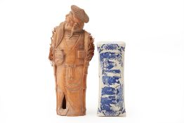 A PORCELAIN PILLOW AND A CARVED BAMBOO FIGURE