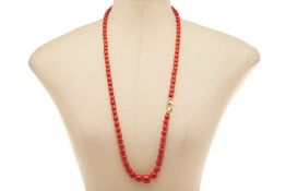 A SINGLE STRAND CORAL BEAD NECKLACE WITH DIAMOND SET CLASP