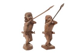 A PAIR OF CARVED WOOD WARRIORS WITH BLOW PIPES/SPEARS