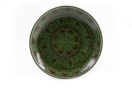 A GREEN POTTERY CHARGER