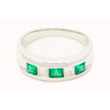 A PLATINUM, EMERALD AND DIAMOND RING