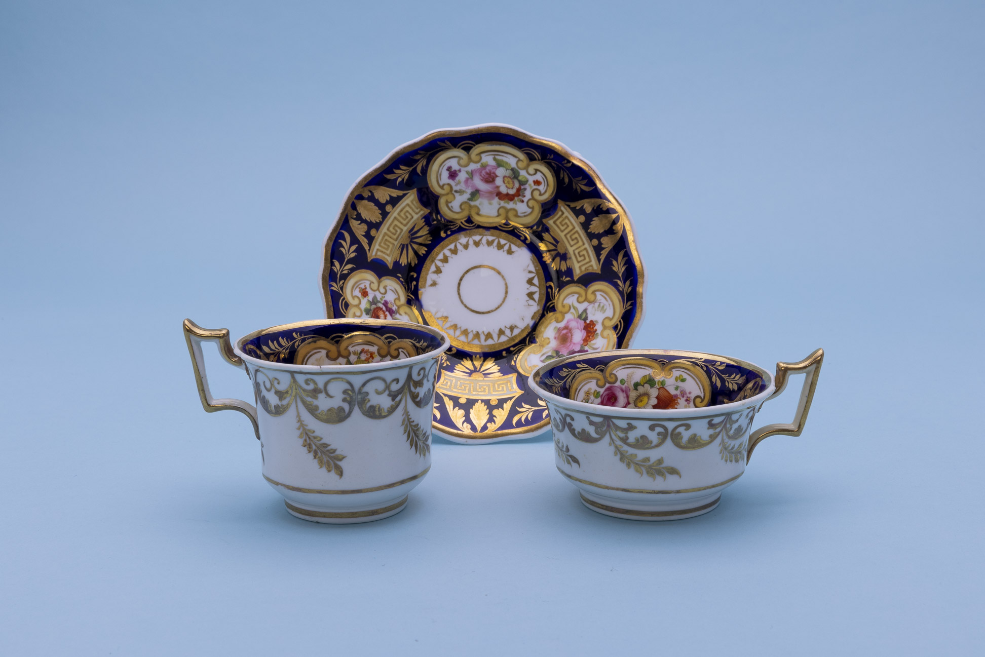 TWO SIMILAR TEA CUPS AND SAUCERS