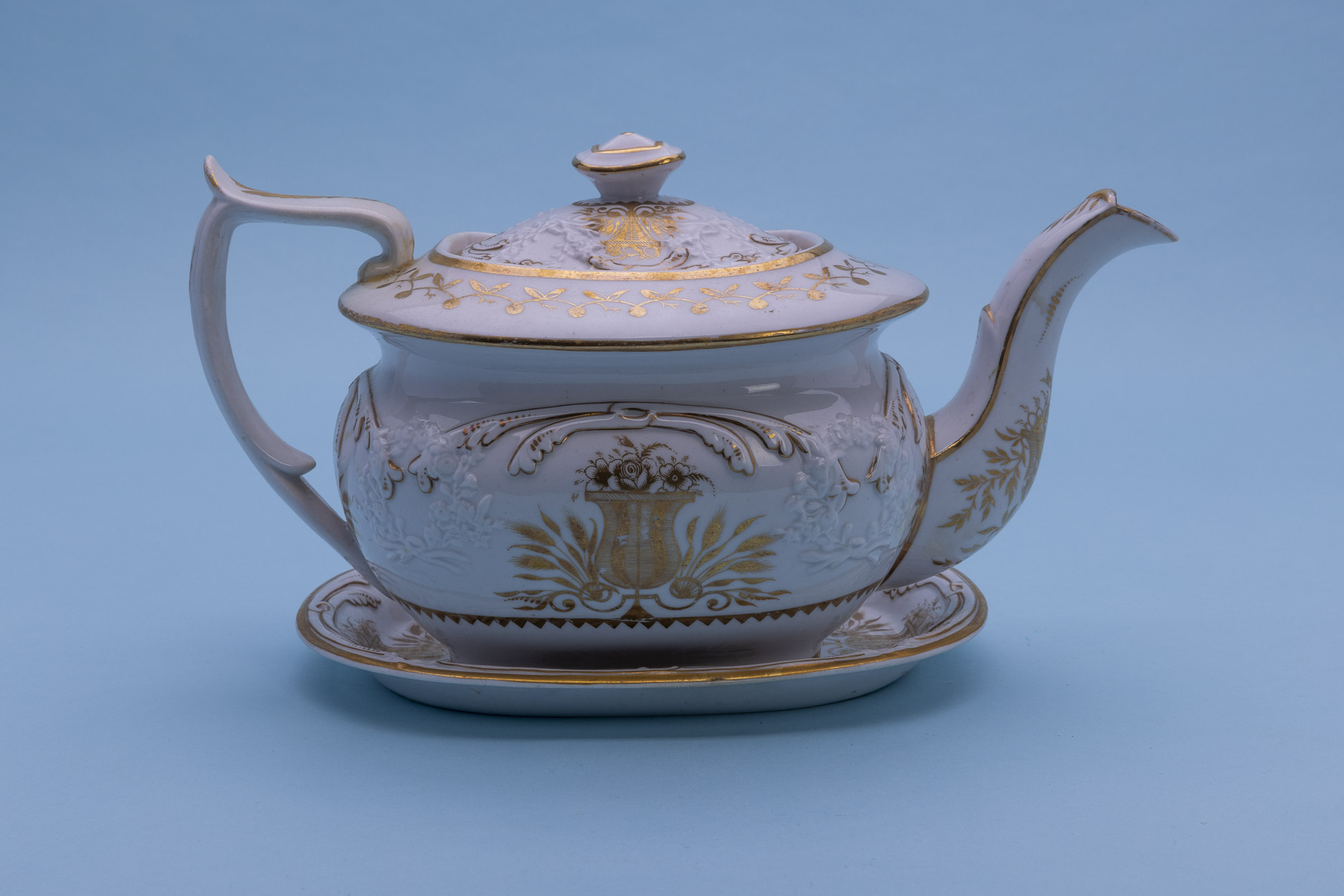 A PORCELAIN TEAPOT AND STAND