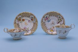 A TEA CUP AND COFFEE CUP WITH SAUCERS