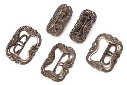 A GROUP OF FIVE WHITE METAL BUCKLES