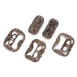 A GROUP OF FIVE WHITE METAL BUCKLES