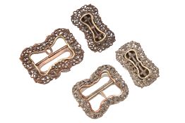 A GROUP OF FOUR WHITE METAL BUCKLES