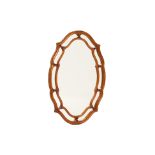 AN OVAL CARVED GILTWOOD MIRROR