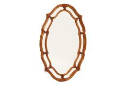 AN OVAL CARVED GILTWOOD MIRROR