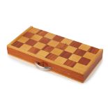 A FOLDING WOODEN CHESSBOARD AND PIECES