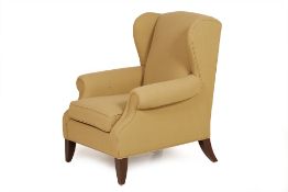 A GREEN UPHOLSTERED WING BACK ARMCHAIR
