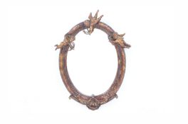 A GILT OVAL WALL MIRROR