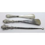 Two silver handle shoe horns and a silver handle button hook