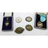 A Victorian silver circular brooch, three other brooches, a/f, and two silver fob medals, cased