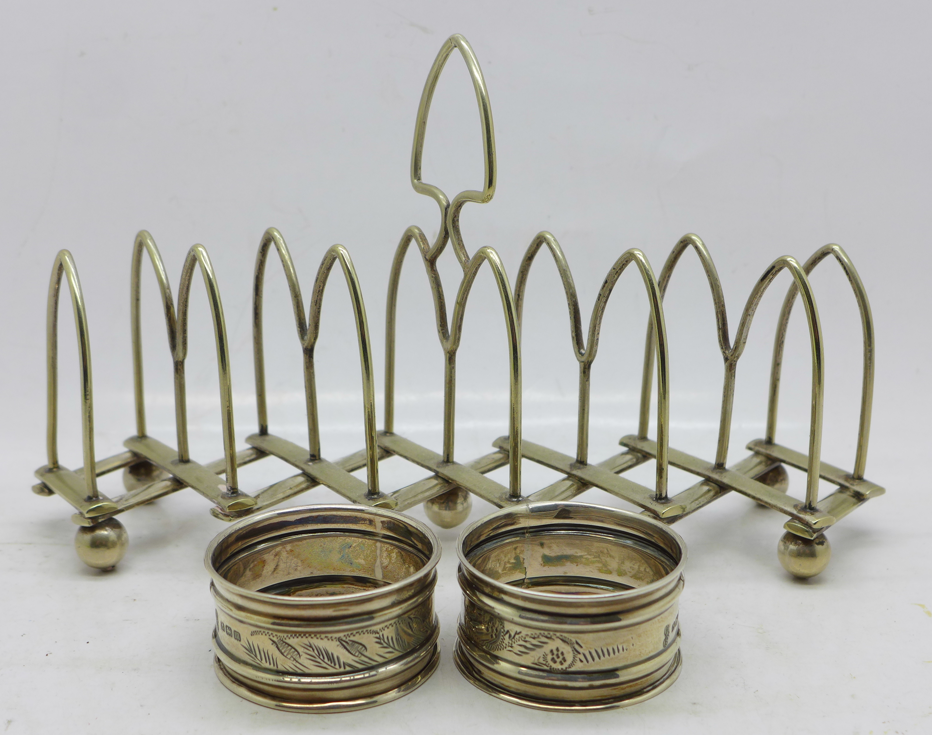 Two silver napkin rings, 18g, and a silver plated extending toast rack