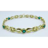 A gilt metal bracelet set with green stones, marked German, K&L