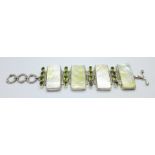 A silver bracelet set with mother of pearl panels and peridot stones and a pearl set toggle, 4cm