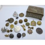 A collection of badges, buttons including military and medallions, in a box with locomotive