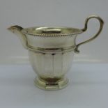 A white metal cream jug, with continental control marks and also stamped 'sil', (tests as silver),