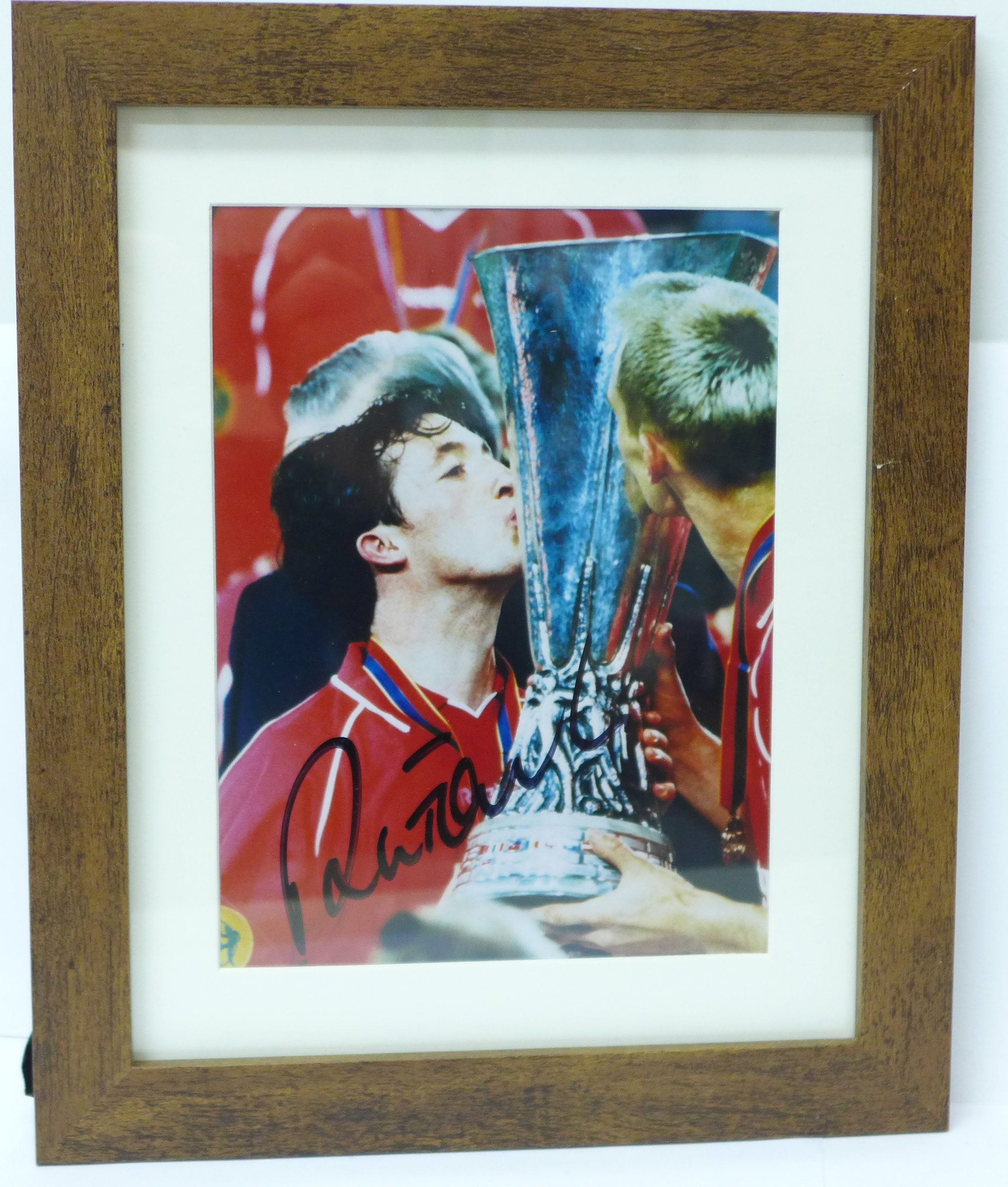 A framed signed photograph of Robbie Fowler with UEFA Cup